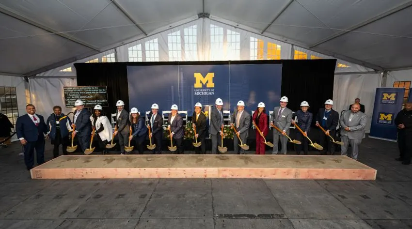 A group of people posing at a groundbreaking with shovels and hard hats